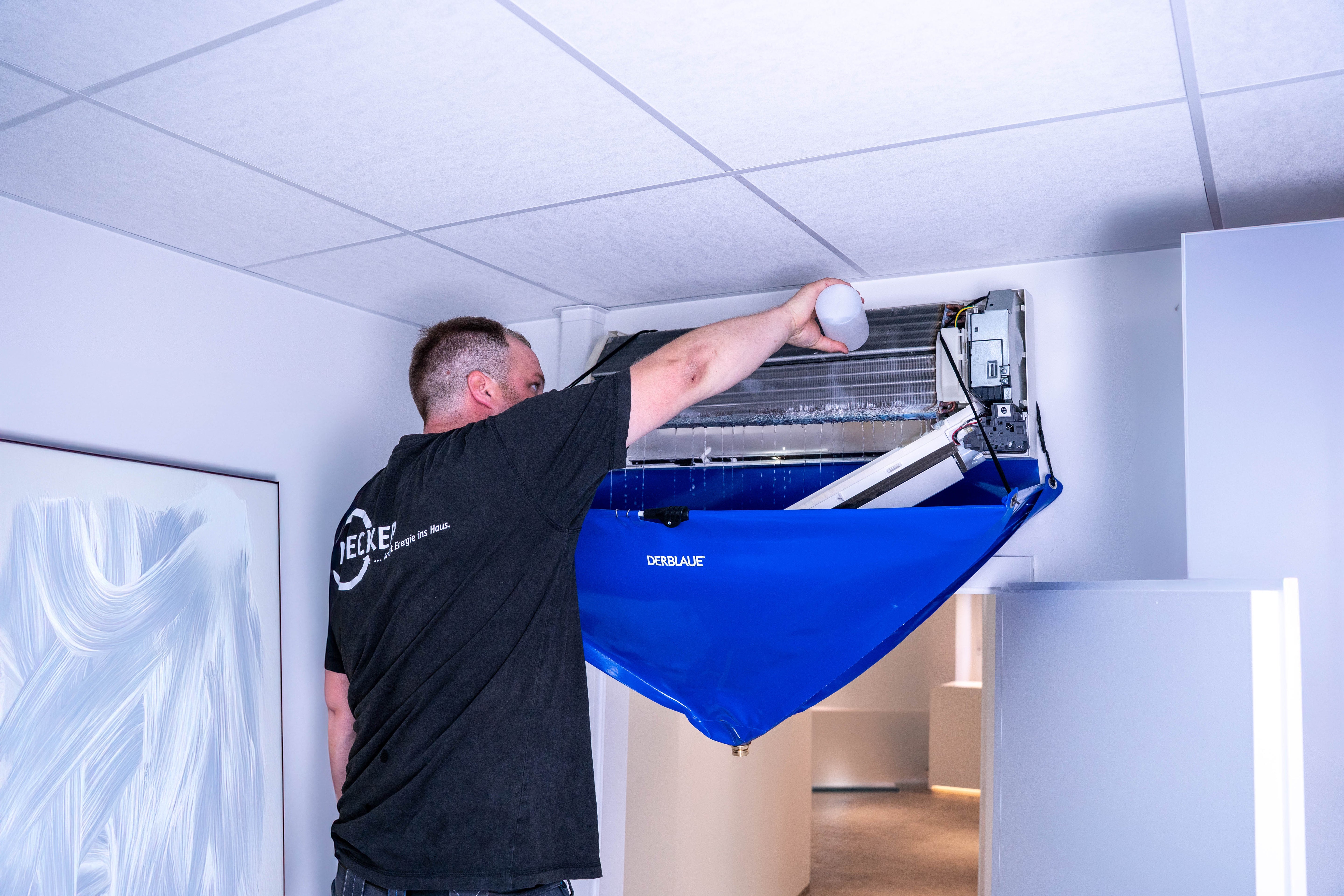 Handwerker macht eine Wartung an einer Klimaanlagen mit dem Falt-Trichter von DERLAUE®. 